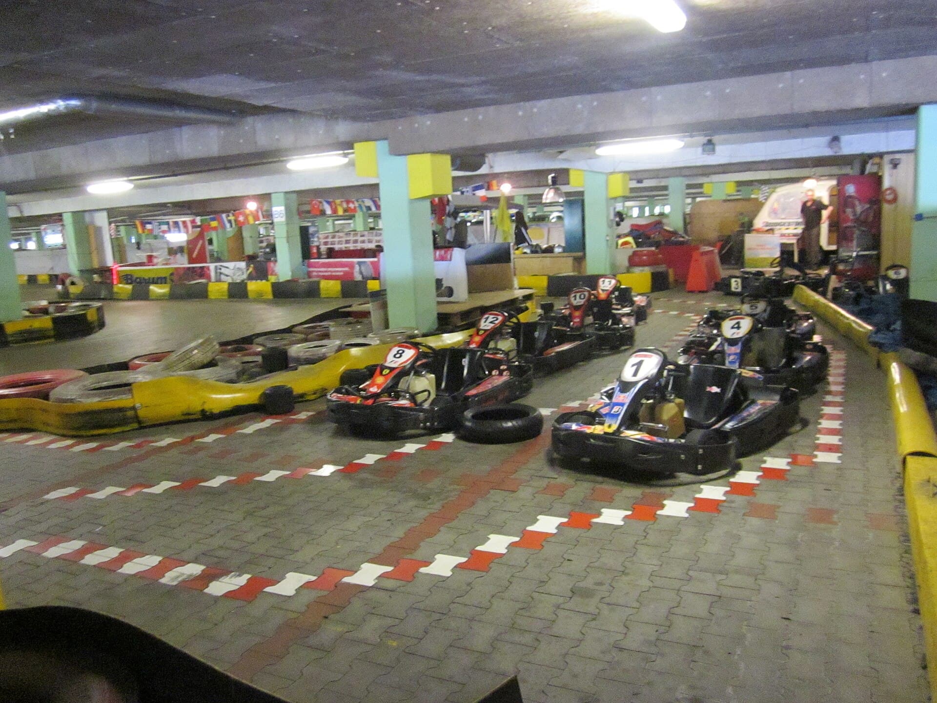 Karts estacionados en una pista cubierta con curvas marcadas en rojo y blanco