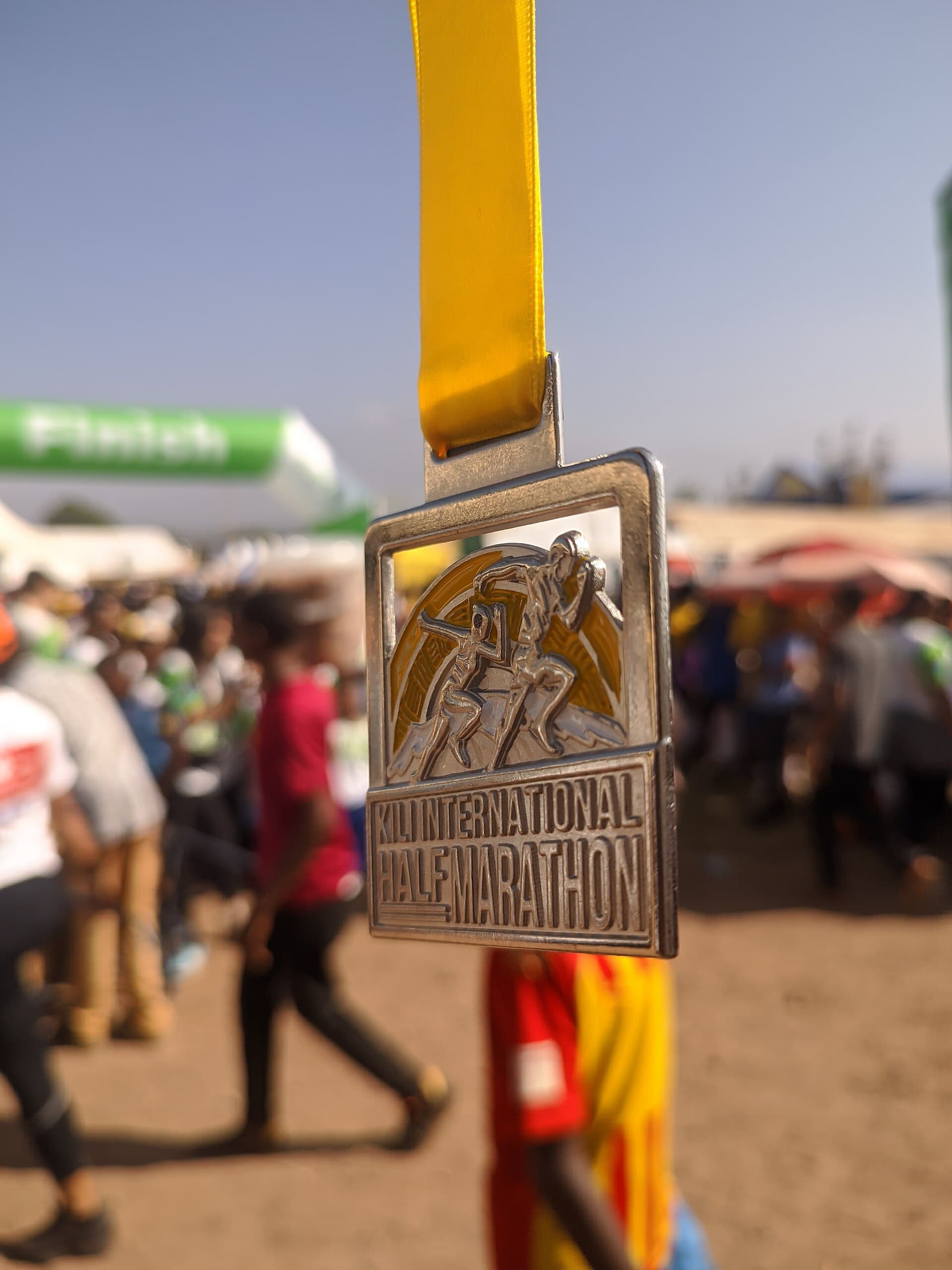 Medalla de finalista de una media maratón, con la llegada de fondo